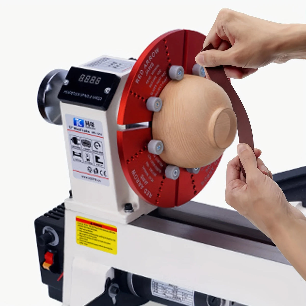 A hand is operating a multi-grit diamond cloth sandpaper roll with a dispenser on a grinding machine.
