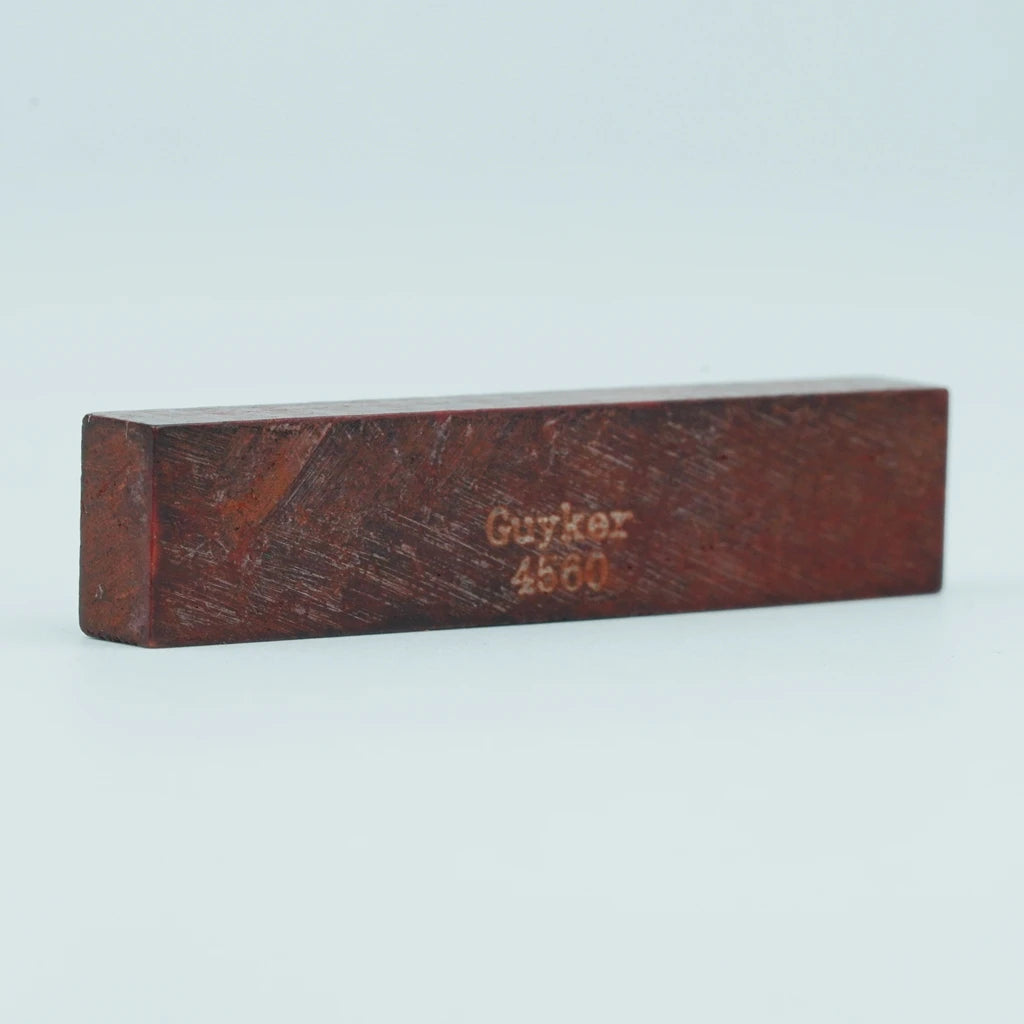A rectangular piece of reddish-brown wood with the name Guyker and number 4560 engraved on it.