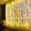 Fenster, dekoriert mit vertikalen, warmweißen LED-Lichterketten, die einen leuchtenden Vorhang erzeugen.