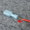 A blue wire connector with a copper tip and red brush is shown on a gray, fuzzy surface.