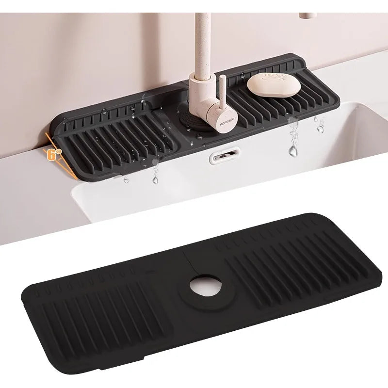 A black foldable silicone sink splash mat is shown installed in a white kitchen sink.
