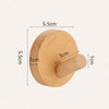 A round, light wood wall hook with a cylindrical handle, measuring 5.5cm in diameter and 5.5cm in height.