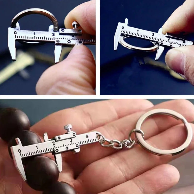 A hand holds a precision metal jewelry measuring ruler and caliper keychain against a dark background.