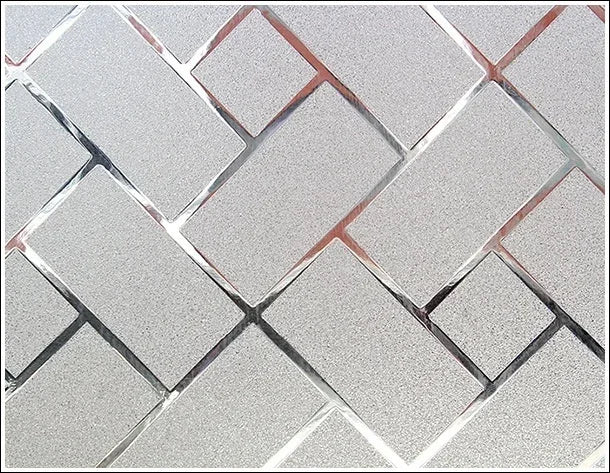 Close-up of frosted window privacy film featuring a diamond lattice pattern with reddish-brown accents.