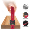 A hand holds a red precision aluminum woodworking ruler against a wooden surface, showing its thickness and corrosion prevent