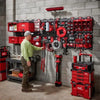 A wall display of various red and black tools, including magnetic bins and power tools, organized for storage.