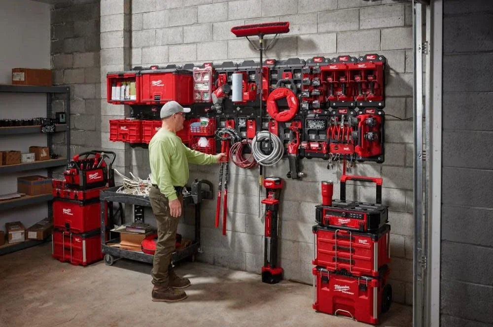 A wall display of various red and black tools, including magnetic bins and power tools, organized for storage.