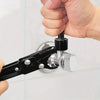 A hand is using a black double-ended pipe wrench set to tighten a silver fitting on a white surface.