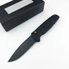 A black folding utility knife with a black handle and blade is shown next to its sheath.