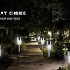A row of modern solar powered outdoor garden lanterns illuminating a pathway in a garden setting.