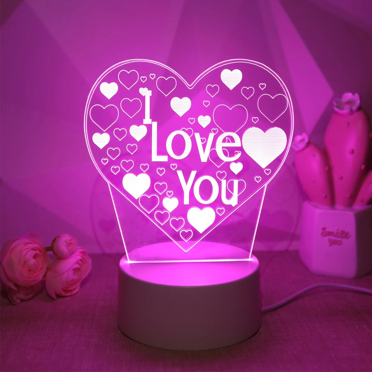 Leuchtendes herzförmiges LED-Nachtlicht mit der Aufschrift "Ich liebe dich" umgeben von kleinen weißen Herzen.