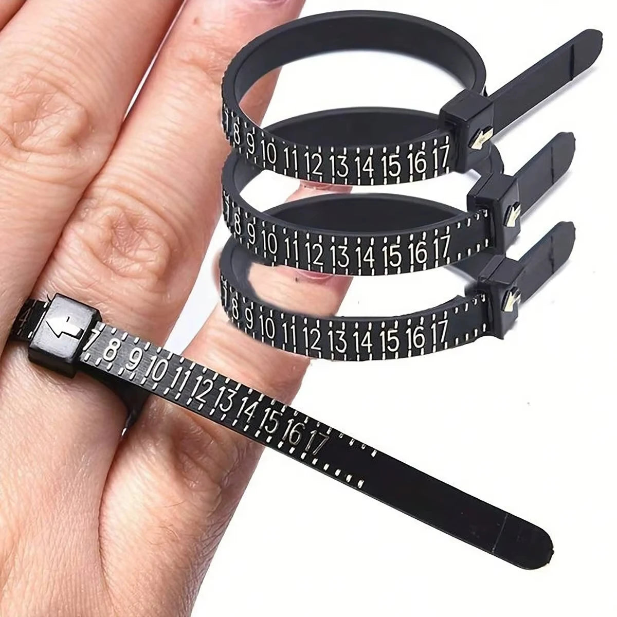 A black accurate finger ring sizer is shown being used on a hand, demonstrating its measurement capability.