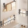 A wall-mounted rack displaying folded beige towels and a rack holding pairs of light-colored adhesive sandals.