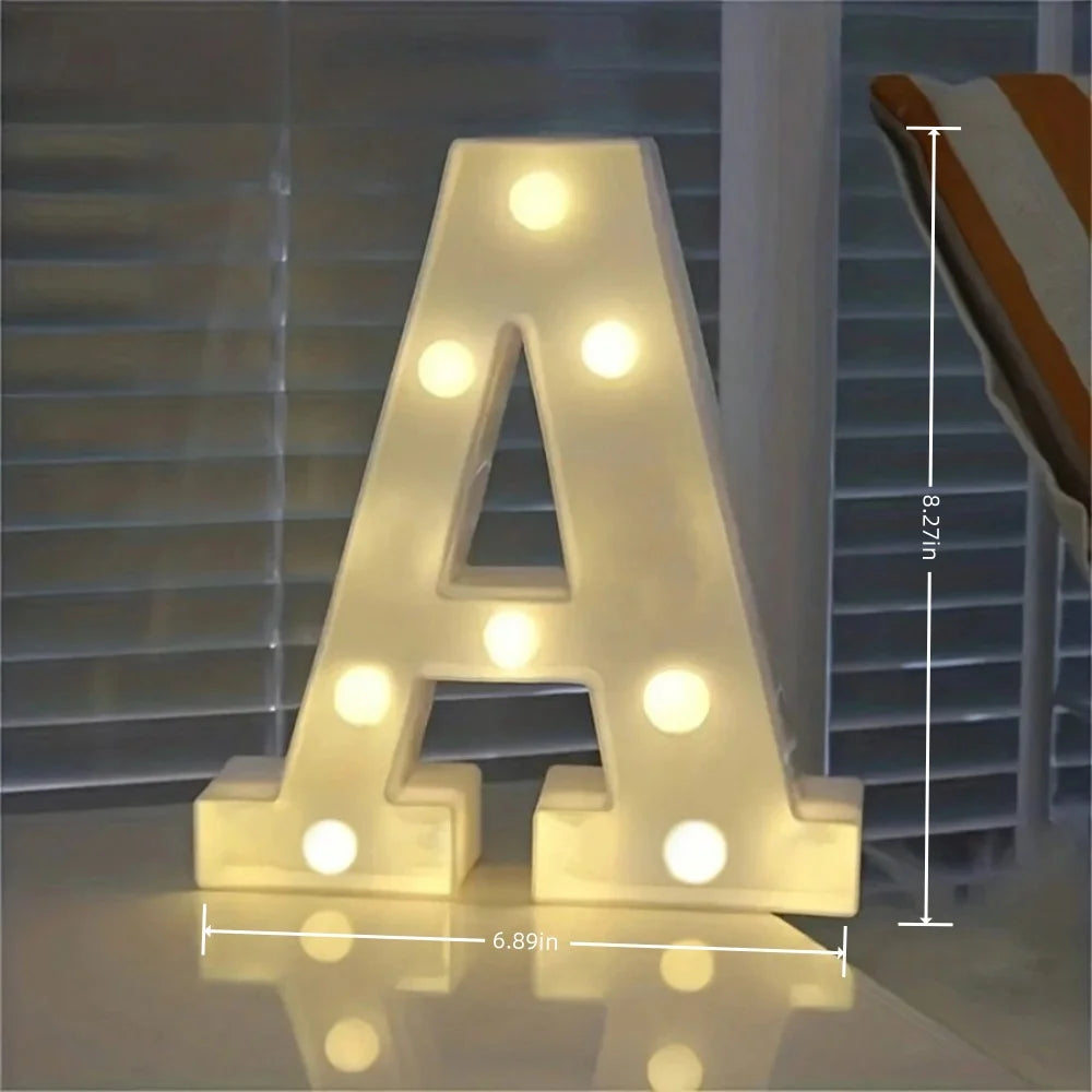 Lámpara nocturna con forma de la letra A, iluminada con luces LED blancas cálidas.