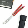 A pair of red folding tactical pen knives with black sheaths and a leather-bound book in the background.