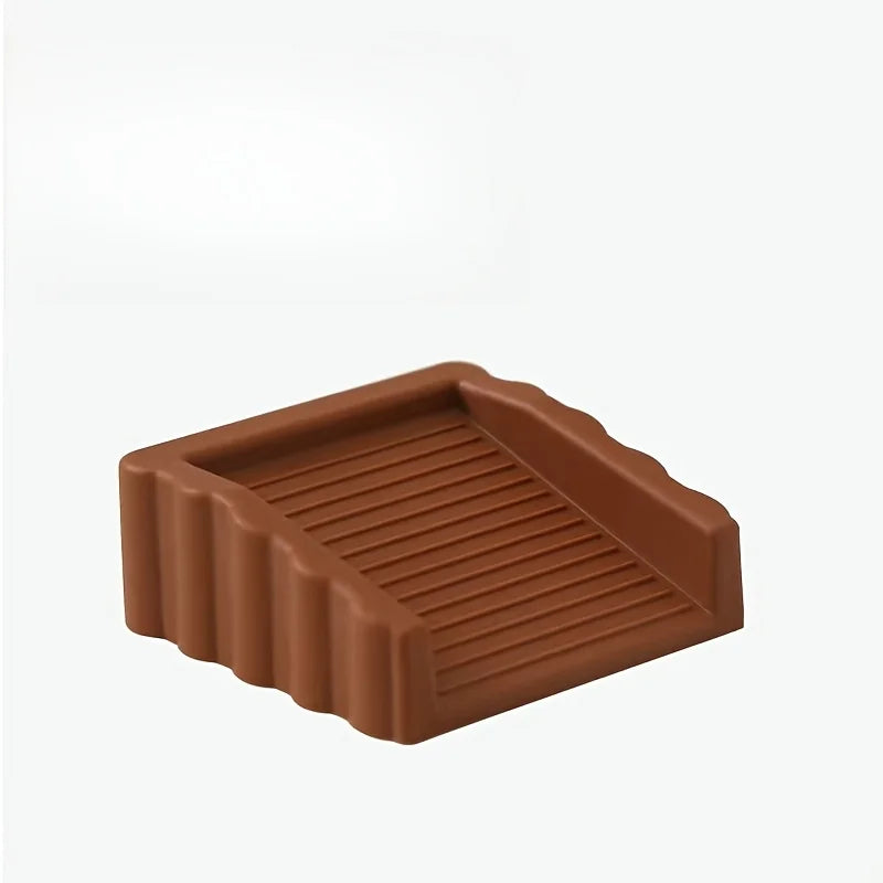 A brown reusable TPR door stop wedge with ribbed texture.