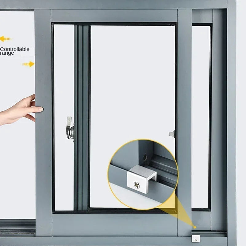 Close-up of a sliding window sash lock stopper mechanism within a gray window frame.