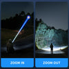 A high-power tactical LED flashlight beam illuminates a dark landscape, with a person crouching in the light.