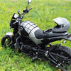 Schwarzes und silbernes Motorrad mit strapazierfähigem Gepäcknetz-Organizer auf einer Wiese.