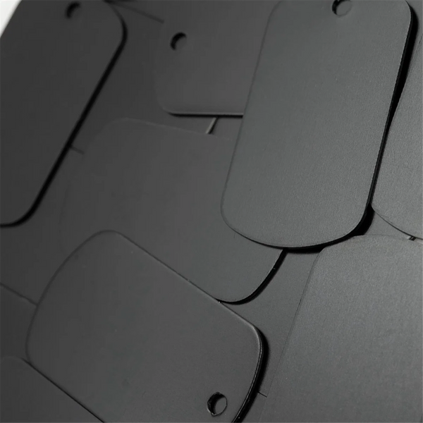 Nahaufnahme von 50 Aluminiumstanz-Tags für Bastelarbeiten und Schlüsselanhänger in Schwarz.