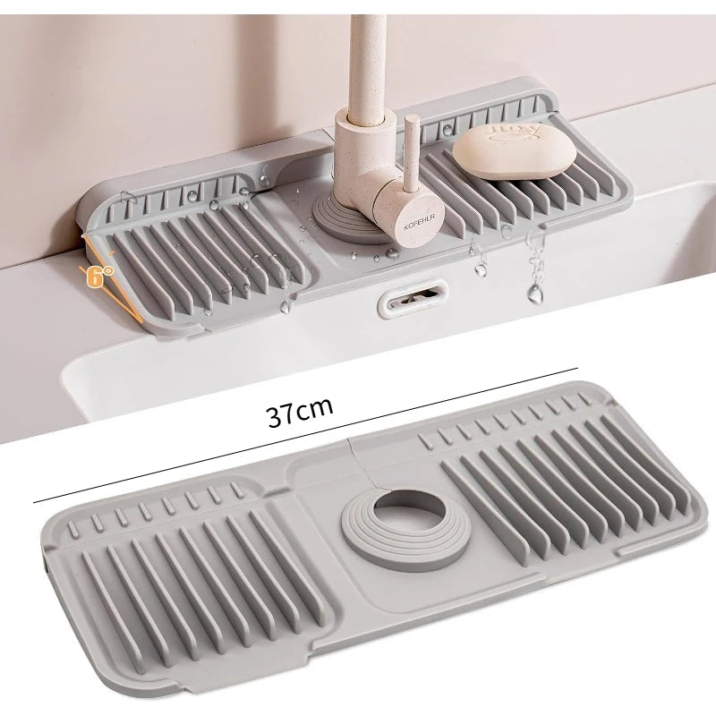 A gray foldable silicone sink splash mat is shown in use on a countertop, featuring various textured drainage slots.