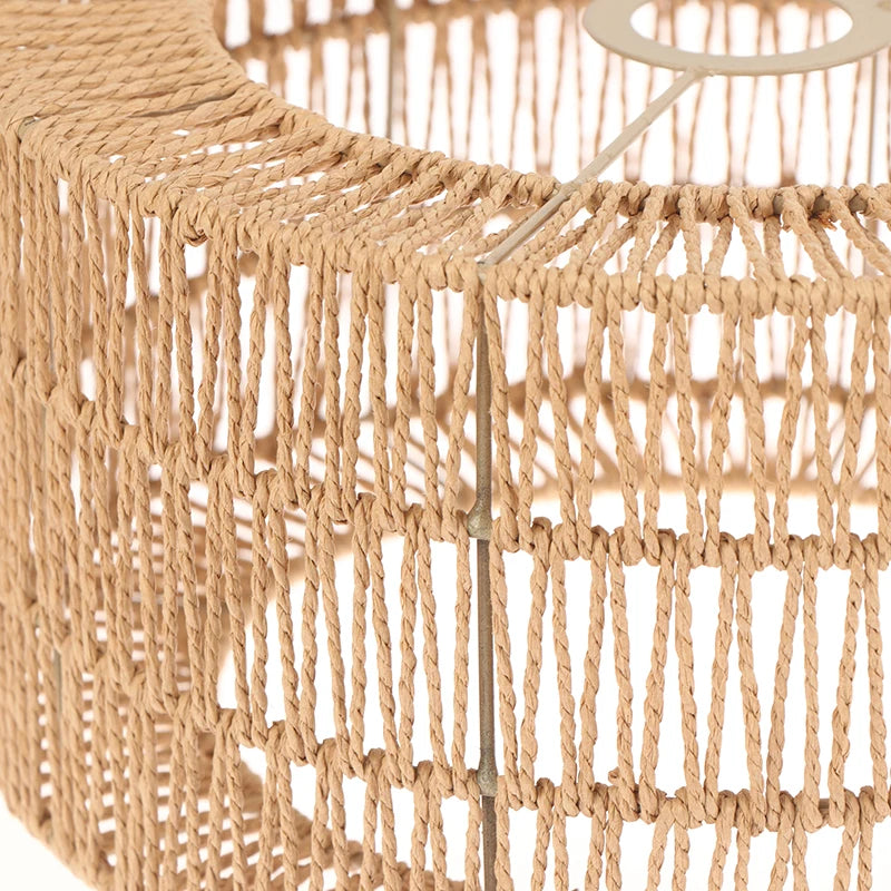 Primer plano de una pantalla de lámpara de cuerda de mimbre beige natural con textura de flecos.