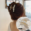 Elegant gold S-shaped metal hair clips with pearl accents shown in a close-up view.