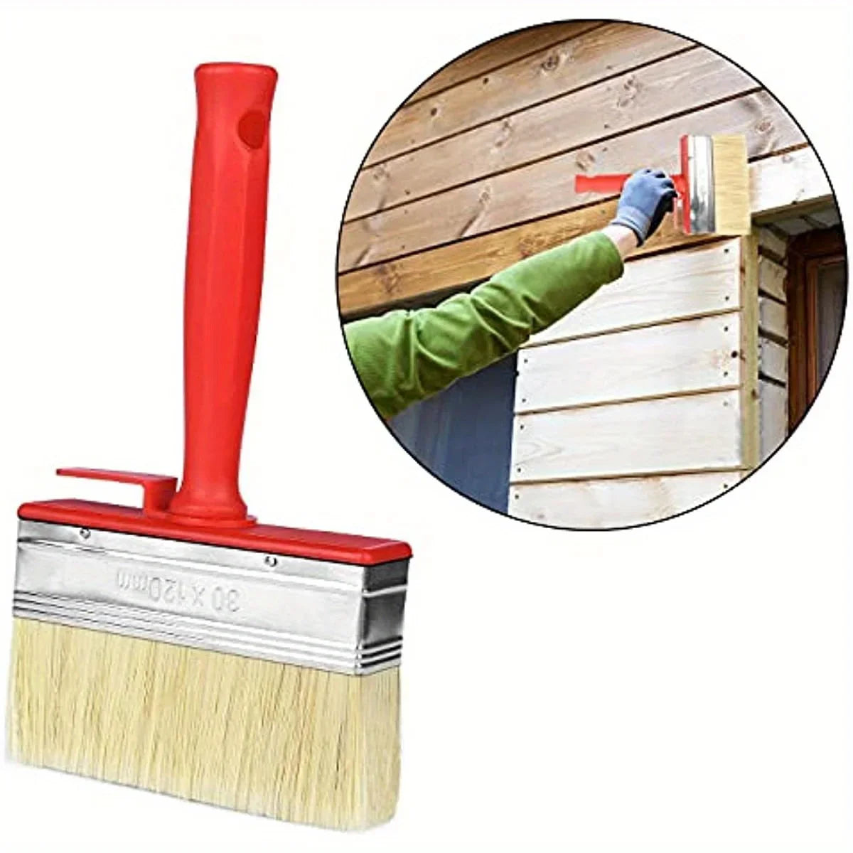 A red paint brush with a large yellow bristles and a wooden house siding in the background.