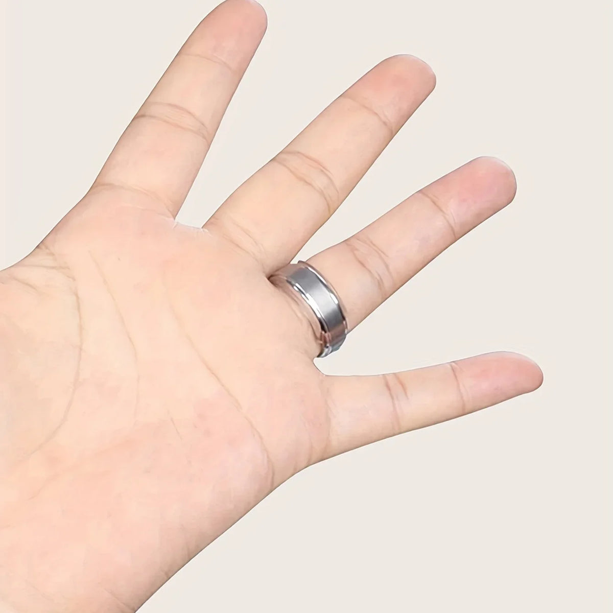 A hand wearing a silver ring, demonstrating an invisible ring sizer kit for jewelry.