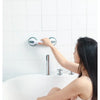 A woman is using a universal non-slip shower grab bar and handrail installed on a white bathtub wall.