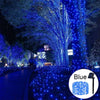 Blue fairy string lights illuminating a tree and pathway at night for outdoor decoration