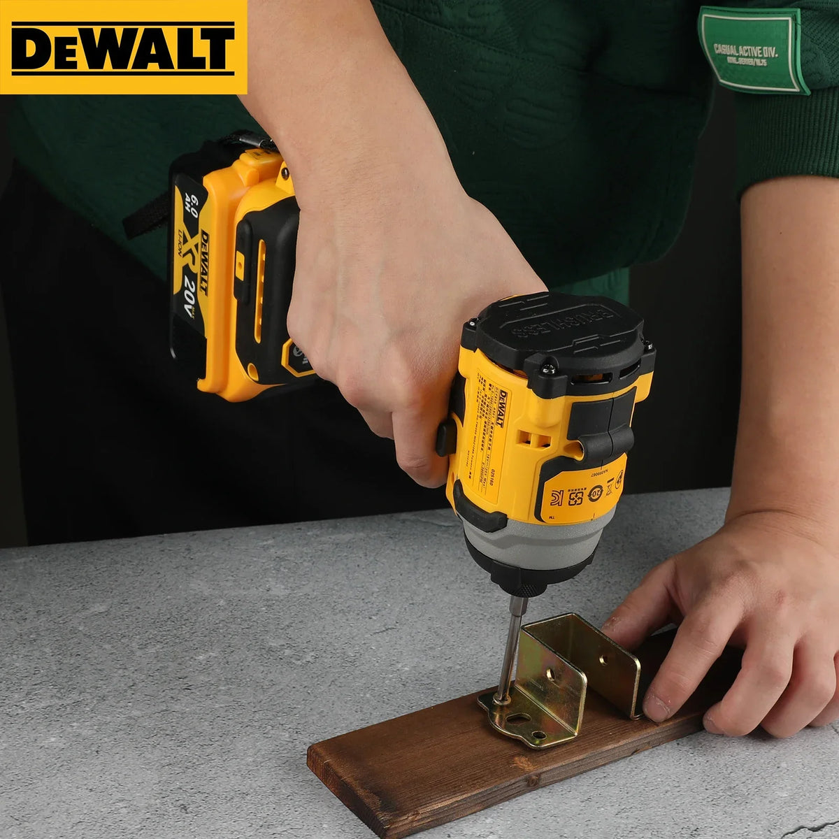 A person is using a yellow and black Dewalt cordless electric screwdriver to drive a screw into a piece of wood.
