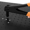 A hand holding a black and orange heavy duty hand rivet gun kit pressing a rivet into a dark surface.