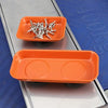 An orange magnetic parts tray filled with small metal screws, nuts, and bolts resting on a blue surface.