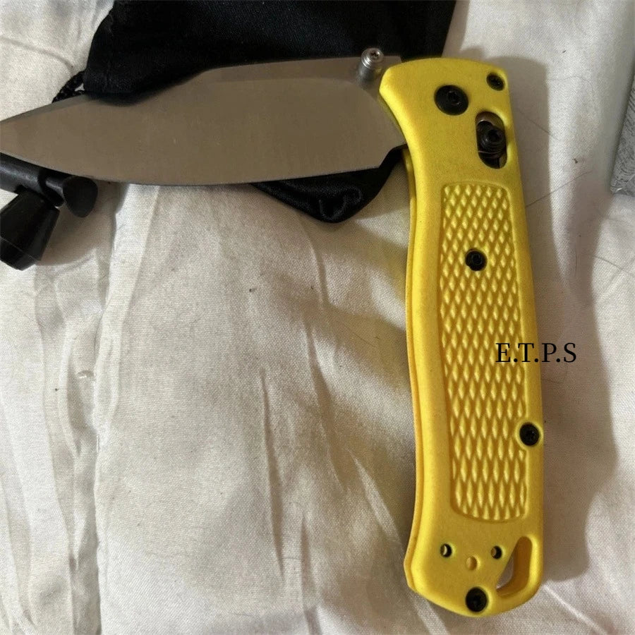 Un couteau de poche pliable jaune avec une gaine noire est montré sur un fond blanc.