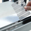 A hand is placing a clear window screen repair patch kit onto a silver frame.