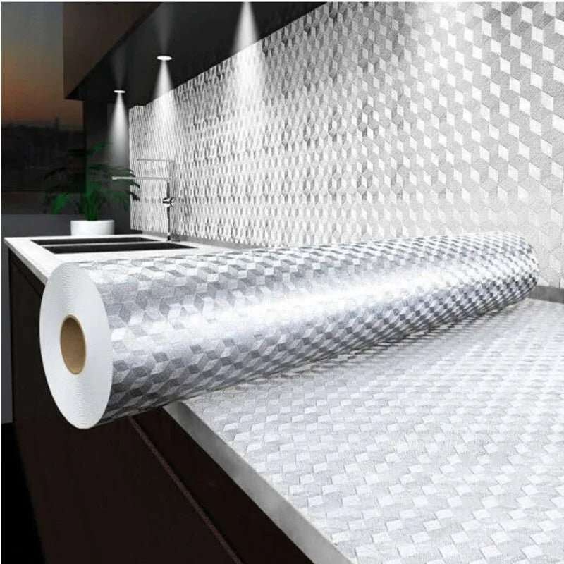 Rouleau de papier d'aluminium argenté auto-adhésif pour murs, exposé sur un comptoir devant un mur texturé.