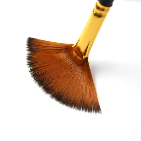 A close-up view of a golden handle and a brown flat brush with a dense, pointed ferrule.