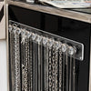 Wandmontierter Acryl-Anhängerorganizer mit silbernen und klaren Kettenhalsketten.