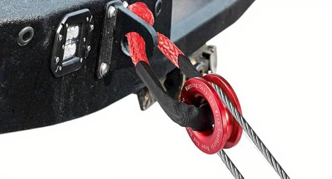 Close-up of a heavy-duty synthetic winch rope and recovery shackle attached to a black metal bracket.
