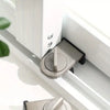 A close-up view of an aluminum sliding window safety lock installed on a white window frame.
