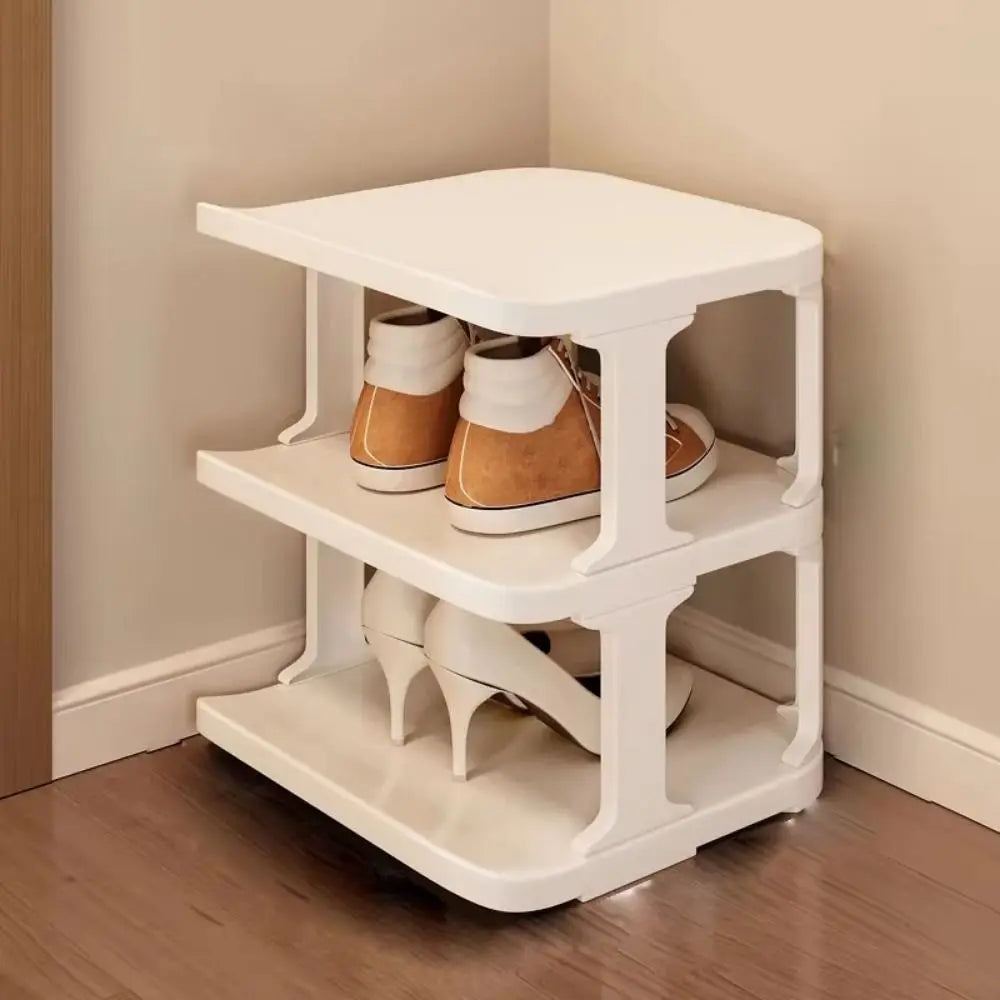 A white stackable vertical shoe rack organizer with two tiers holding pairs of brown ankle boots.