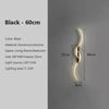 A black modern LED wall sconce with a curved design mounted on a wall.