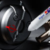 A close-up view of a white paint marker pen with a tip, positioned near a dark metal object marked with a red prohibition sym