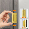 Una mano opera un mecanismo de pestillo de refuerzo para puerta de aluminio en un panel de puerta gris.