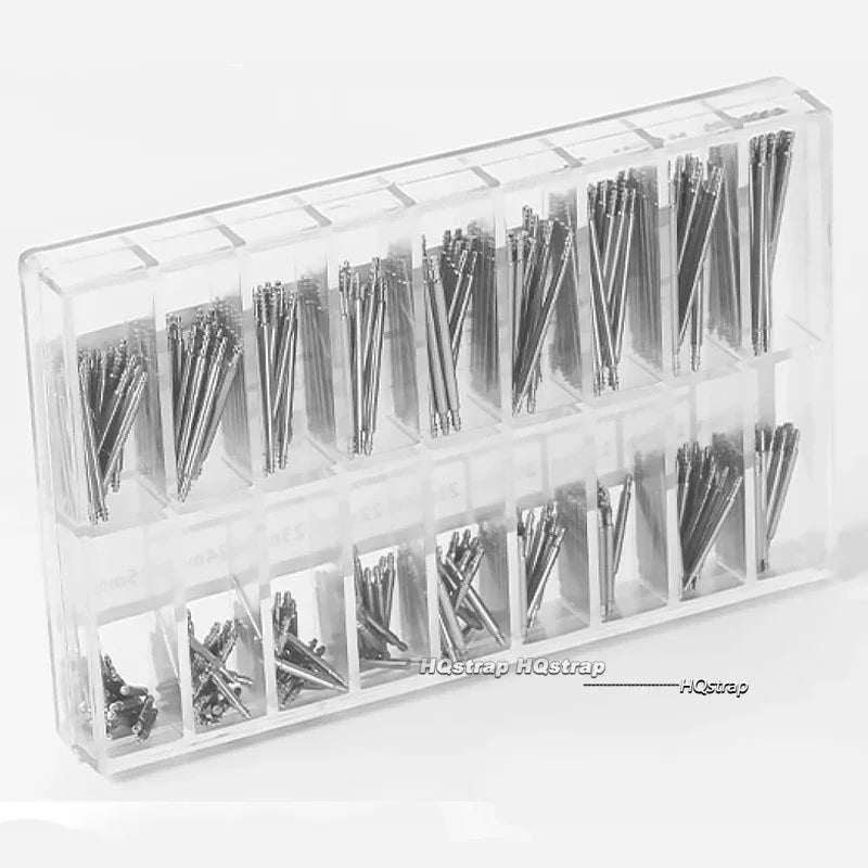 A clear plastic case holding numerous stainless steel watch repair pins and spring bars.