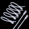 A collection of white reusable nylon cable ties with screw holes arranged against a black background.