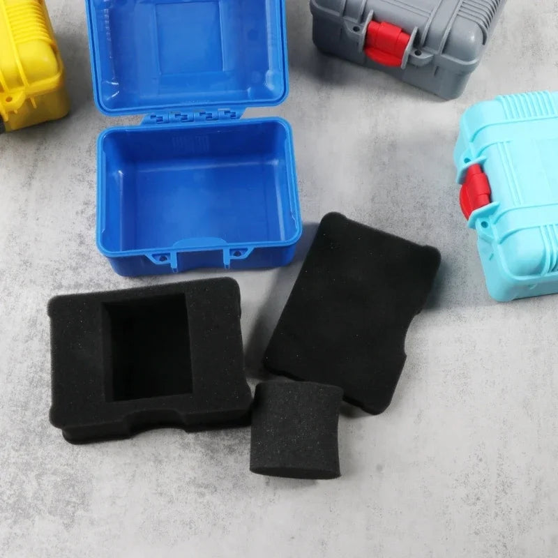 Various blue and black impact-resistant watch storage cases and components are displayed on a gray surface.