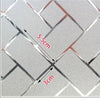 Close-up of a frosted window privacy film featuring a diamond pattern with measurements marked.
