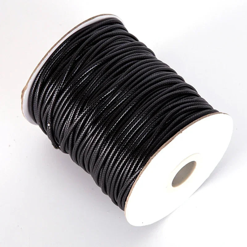 A spool of black waxed cord rope used for DIY jewelry making.